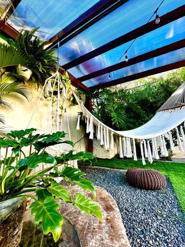 a patio with a hammock hanging from a building at Airport Traveler's home. in Alajuela City