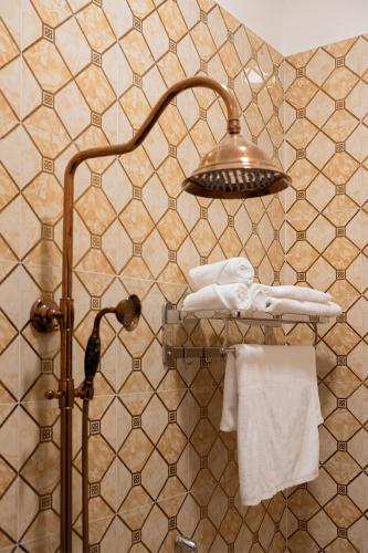 a bathroom with a shower with a light and towels at Mekong Gia Lai Hotel - Me Kong Pleiku in Pleiku