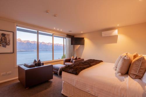 a bedroom with a large bed and a large window at Lordens Apartment 1 in Queenstown