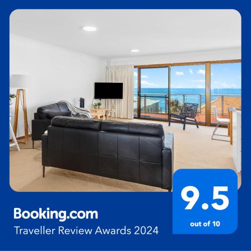 uma sala de estar com um sofá preto e uma televisão em Amazing Ocean Views At This Exclusive 4 BR Holiday Home em McCracken