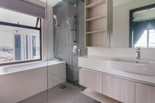 La salle de bains blanche est pourvue d'un lavabo et d'une douche. dans l'établissement A Cozy & Lovely High-Floor 3BR Suite City Views, à Johor Bahru