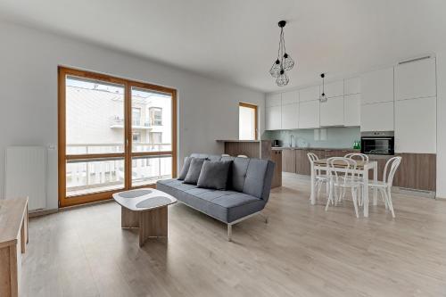 sala de estar con sofá y mesa en Mila Baltica by Grand Apartments, en Gdansk