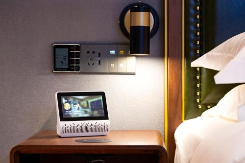 a small laptop computer sitting on a table in a bedroom at Nostalgia S Hotel Kunming Old Street 时光漫步S酒店 昆明火车北站穿心鼓楼地铁站店 Free fresh ground coffee,Free laundry service in Kunming