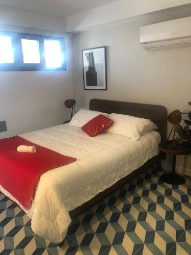 ein Schlafzimmer mit einem Bett mit einer roten Decke darauf in der Unterkunft Apartamento Casco Antiguo in Panama-Stadt