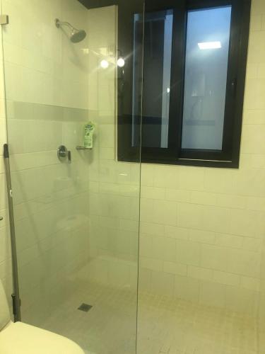 a bathroom with a glass shower with a window at Apartamento Casco Antiguo in Panama City
