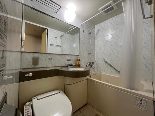 a bathroom with a toilet and a sink and a tub at Hotel Alpha-One Koriyama Higashiguchi in Koriyama