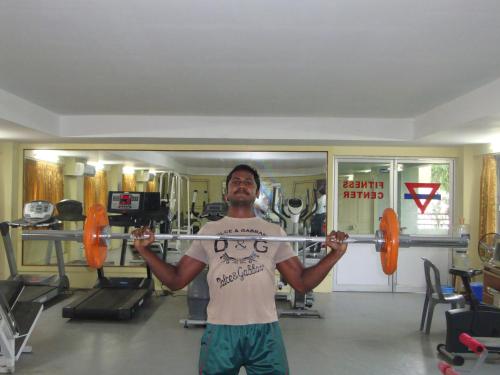 a man holding a barbell in a gym at YMCA PROGRAM CENTRE in Salem
