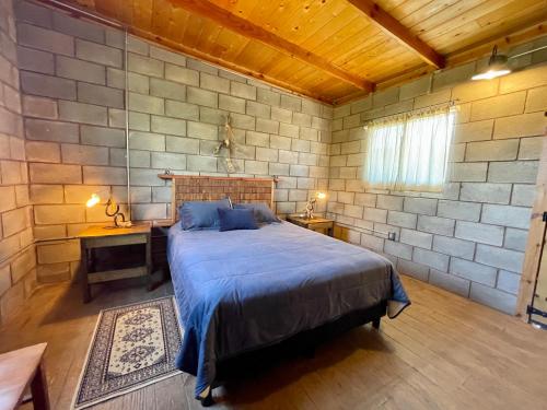 a bedroom with a bed in a stone wall at Sn Tony Hotel & Spa in Valle de Guadalupe