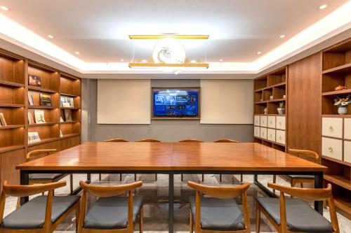 a conference room with a large wooden table and chairs at Nostalgia S Hotel Kunming Old Street 时光漫步S酒店 昆明火车北站穿心鼓楼地铁站店 Free fresh ground coffee,Free laundry service in Kunming