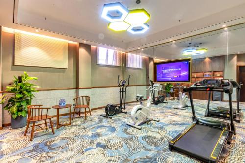a room with a gym with a flat screen tv at Nostalgia S Hotel Kunming Old Street 时光漫步S酒店 昆明火车北站穿心鼓楼地铁站店 Free fresh ground coffee,Free laundry service in Kunming