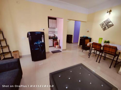 a living room with a black refrigerator and a table at DREAMS ABODE studio apartment in Guwahati