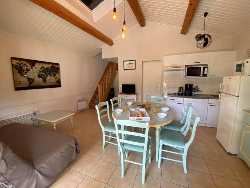 une cuisine et une salle à manger avec une table et des chaises dans l'établissement Maison 2 chambres avec terrasse et parking près forêt, plage et pistes cyclables à Saint-Jean-de-Monts - FR-1-323-522, à Saint-Jean-de-Monts