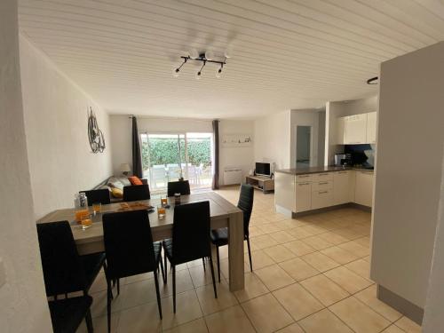 une cuisine et une salle à manger avec une table et des chaises dans l'établissement Maison spacieuse au cœur de la verdure, proche de la forêt, idéale pour familles et cyclistes - FR-1-323-520, à Saint-Jean-de-Monts
