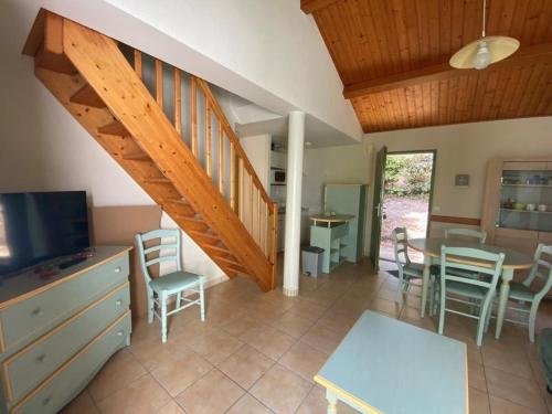 - un salon avec un escalier, une table et des chaises dans l'établissement Maison proche forêt, 2 chambres, terrasse et parking - 6 personnes, St Jean de Monts - FR-1-323-523, à Saint-Jean-de-Monts