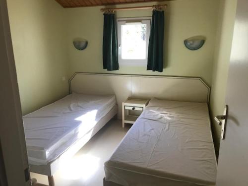 deux lits dans une chambre avec une fenêtre dans l'établissement Spacieuse maison à Saint Jean de Monts proche forêt avec terrasse, 3 chambres et parking privé - FR-1-323-524, à Saint-Jean-de-Monts
