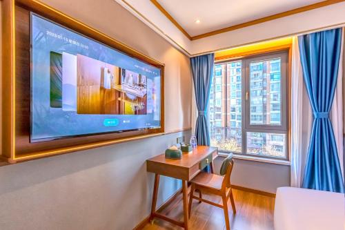 a living room with a table and a large tv at Nostalgia S Hotel Kunming Old Street 时光漫步S酒店 昆明火车北站穿心鼓楼地铁站店 Free fresh ground coffee,Free laundry service in Kunming