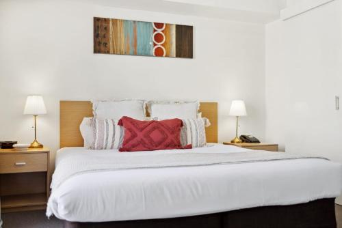 a bedroom with a large white bed with red pillows at 1BRD 1BTH 1PRK - Northbridge Apartment in Perth