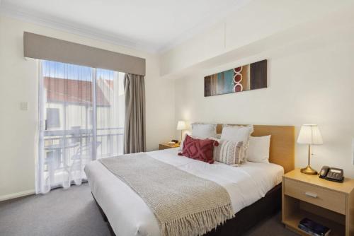 a bedroom with a large bed and a large window at 1BRD 1BTH 1PRK - Northbridge Apartment in Perth
