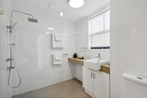 a white bathroom with a sink and a shower at 1BRD 1BTH 1PRK - Northbridge Apartment in Perth