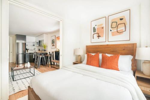 a bedroom with a large white bed with orange pillows at 75-2A furnished 1BR W D Elev central park in New York