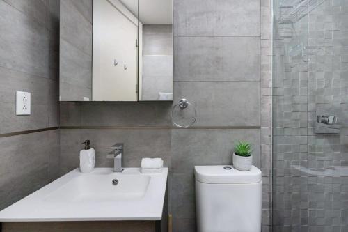 een badkamer met een wastafel, een toilet en een spiegel bij 75-2A furnished 1BR W D Elev central park in New York