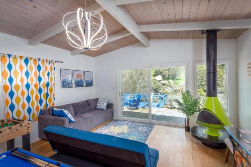 Una sala de estar con un sofá y una lámpara de araña. en Retro House on the River !, en Three Rivers