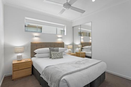 a bedroom with a large bed and a mirror at Private 2-Bed Apartment & 5 minutes walk to QPAC in Brisbane