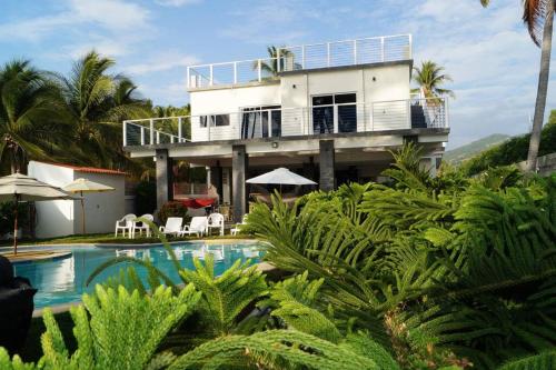 a house with a swimming pool in front of a house at Casa BLUE paradise HOUSE in El Corozal