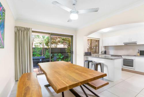 a kitchen with a wooden table and a dining room at Villa 1 and Villa 2 in Gold Coast