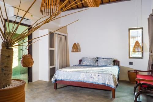 1 dormitorio con 1 cama y una maceta en Blue Beach Village Homestay, en Hoi An