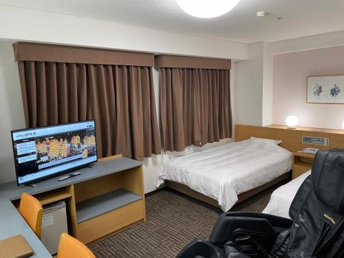 a hotel room with a bed and a flat screen tv at Hotel Alpha-One Akita in Akita