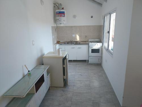 a kitchen with white appliances and a tile floor at Talamochita in Santa Rosa de Calamuchita