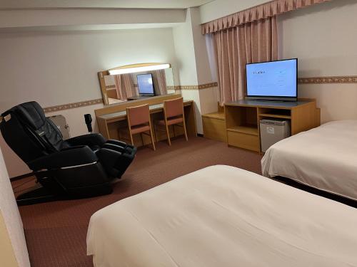 a hotel room with two beds and a television at Hotel Alpha-One Niigata in Niigata