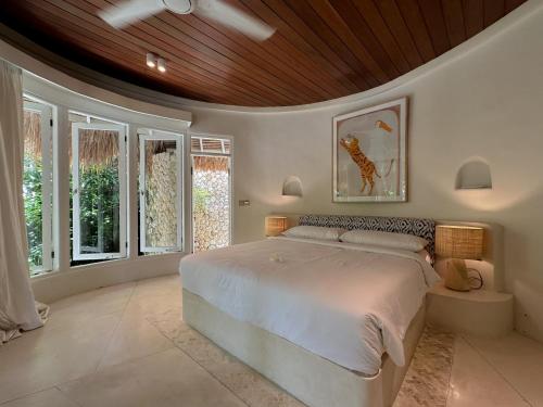 a bedroom with a large bed with a wooden ceiling at Bodhi Bingin in Uluwatu