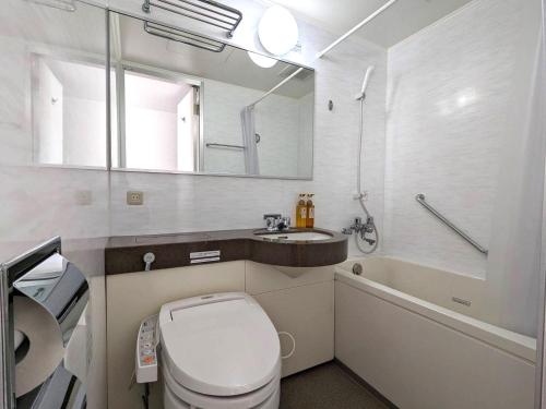 a bathroom with a toilet and a sink and a mirror at Hotel Alpha-One Yokohama Kannai in Yokohama