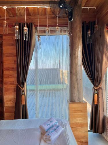a bedroom with a window with two towels on a bed at Oceanside Villa Phuquy Island in Cu Lao Thu