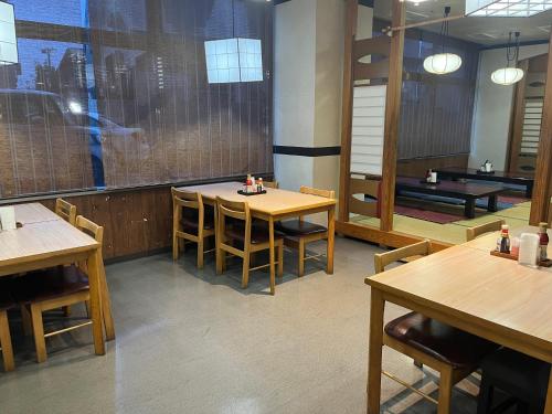 comedor con mesas y sillas de madera y ping pong en Hotel Alpha-One Yonezawa en Yonezawa