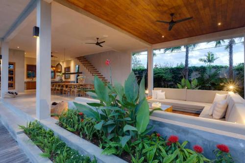 an outdoor living room of a house with a couch at ZIN Berawa Villas & Bungalows in Canggu