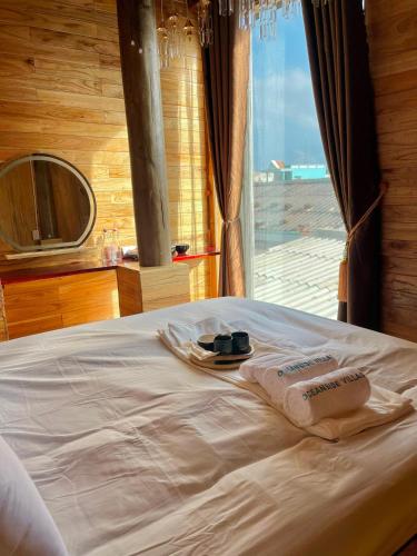 a bed with towels and a mirror and a window at Oceanside Villa Phuquy Island in Cu Lao Thu