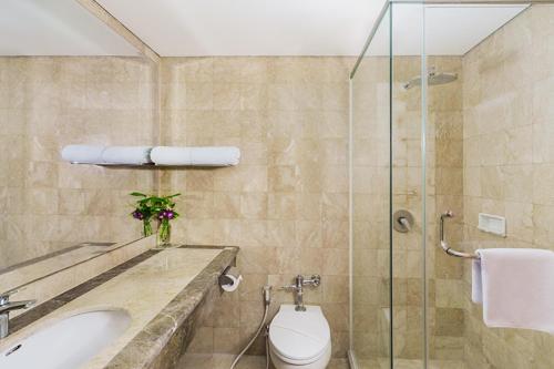 a bathroom with a sink and a toilet and a shower at Tavia Heritage Hotel in Jakarta