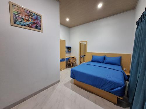 1 dormitorio con 1 cama azul en una habitación en Say Villa, en Kejayan