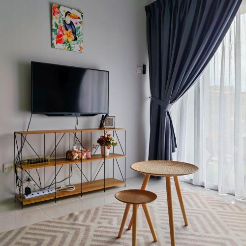 a living room with two stools and a flat screen tv at D'Elegant Suite - Emerald Avenue in Cameron Highlands