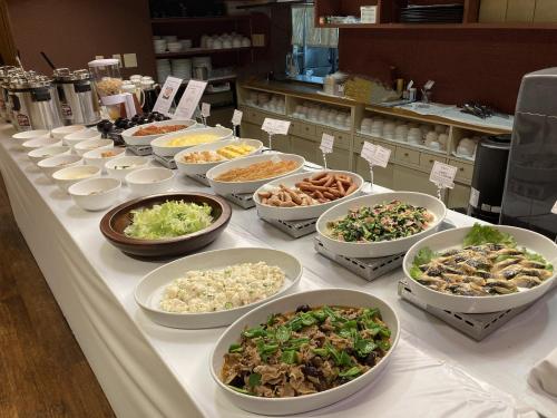 um buffet com muitas tigelas de comida numa mesa em Hotel Alpha-One Iwaki em Iwaki