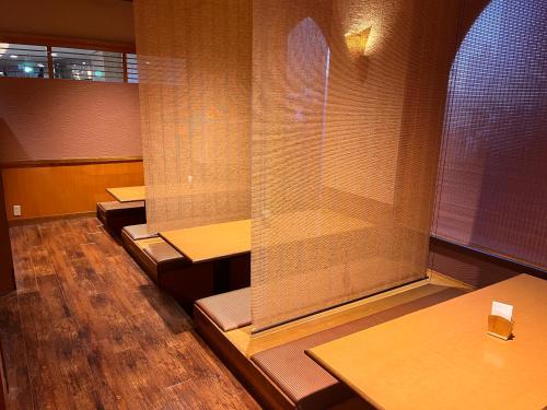 Hotel Alpha-One Iwaki في إيواكي: صف من الطاولات في غرفة ذات أرضيات خشبية