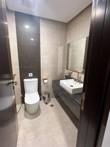 a bathroom with a toilet and a sink at بوابة منى الذهبي in Al ‘Azīzīyah