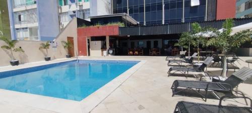 una gran piscina con sillas y un edificio en Hotel sol vitória Marina, en Salvador