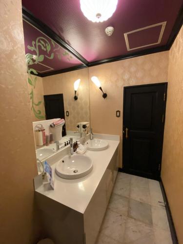 een badkamer met 2 wastafels en een grote spiegel bij ラブホテル tabasaサンレモ in Fukuoka