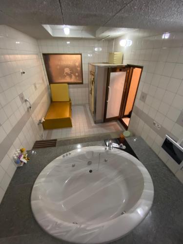een badkamer met een groot wit bad in een kamer bij ラブホテル tabasaサンレモ in Fukuoka