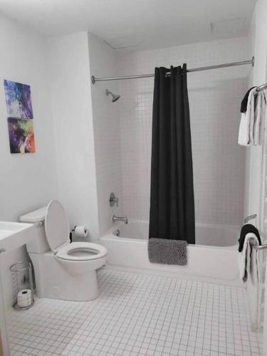 a white bathroom with a toilet and a shower at 629 Lofts 806 - A KCM Property in Cleveland