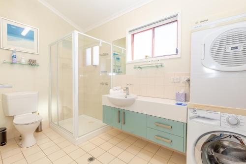 a bathroom with a sink and a washing machine at Mariners Cove at Paynesville in Paynesville